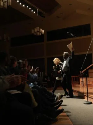 RogJenéa Fisher walks off the stage with Joseph Lawson after her speech