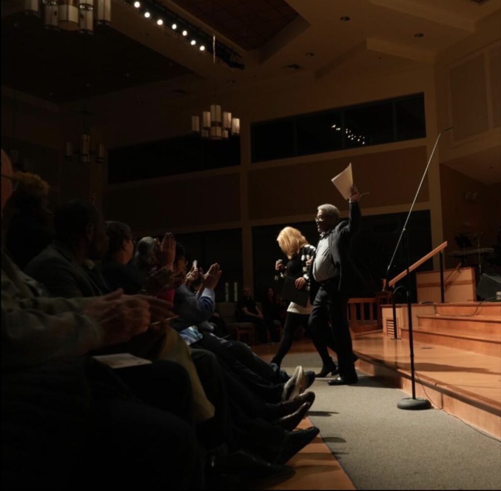 RogJenéa Fisher walks off the stage with Joseph Lawson after her speech